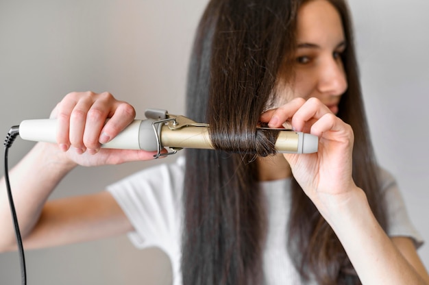 female straightening her hair