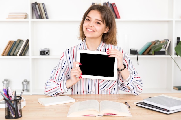 Бесплатное фото Студентка держит пустой цифровой планшет