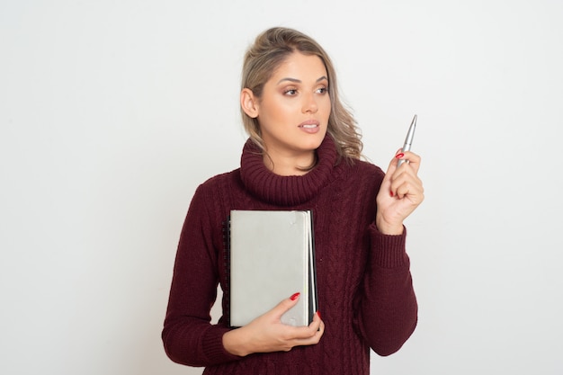 Female student holding books and pen