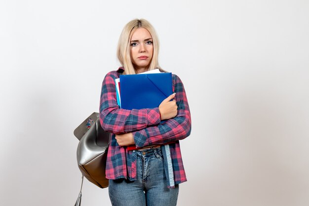 female student holding different files on light-white