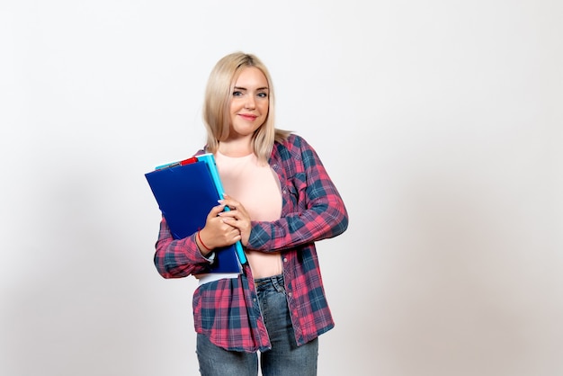 female student holding different files on white