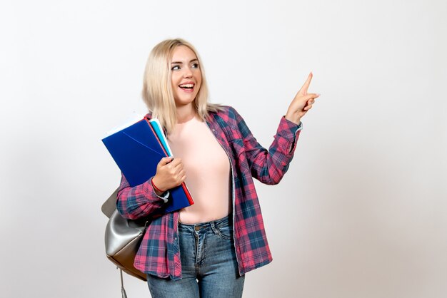 female student holding different files on white