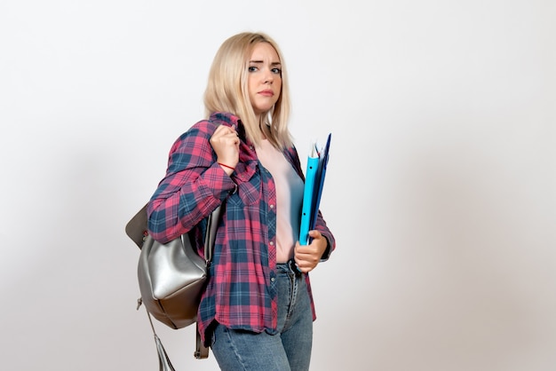 female student holding different files on white