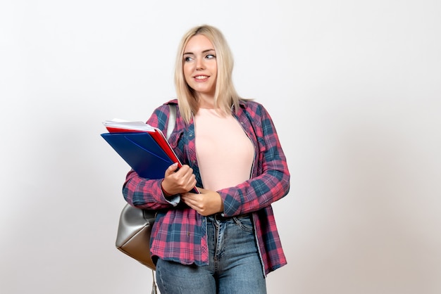 Studentessa in possesso di file diversi con il sorriso su bianco