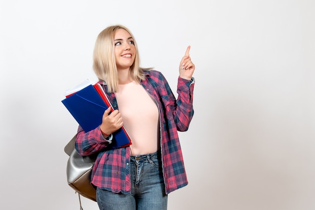 female student holding different files with smile on white