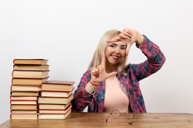 female student just sitting with different books on white