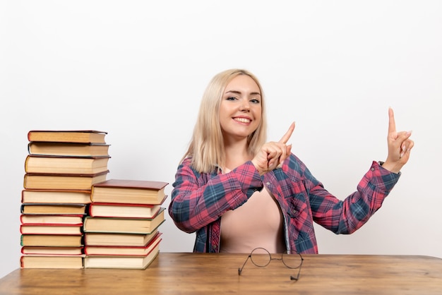 female student just sitting with different books on white