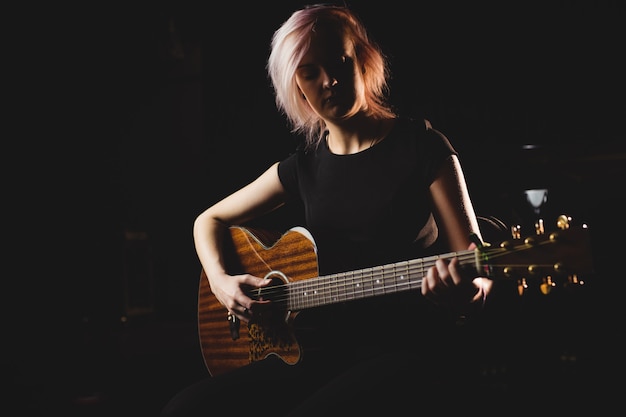 Free photo female student playing guitar