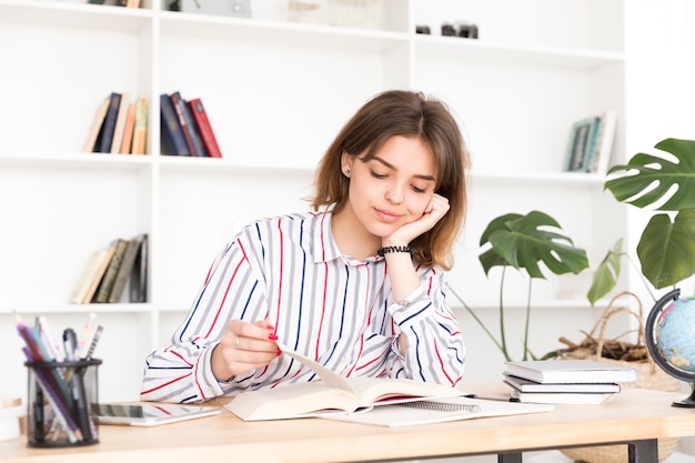 Female student reading at wooden desk