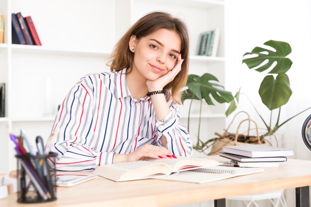 女子学生の本と座っていると笑顔