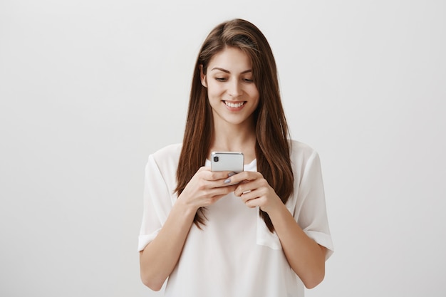 Female student using mobile phone, shopping online or texting