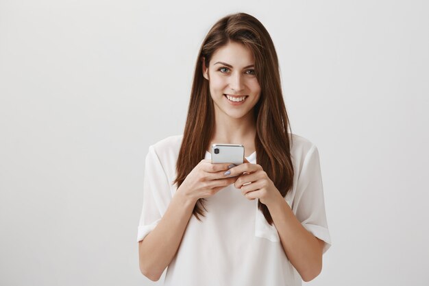 Female student using mobile phone, shopping online or texting