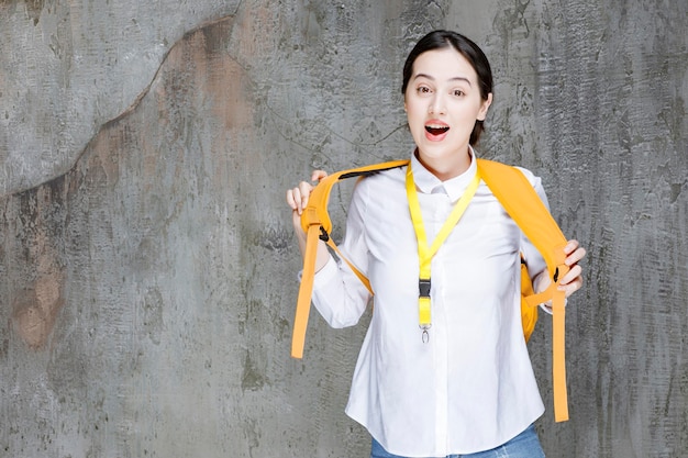 Free photo female student wearing yellow backpack feeling happy. high quality photo