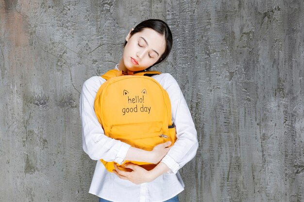 Female student wearing yellow backpack on front sleeping. High quality photo