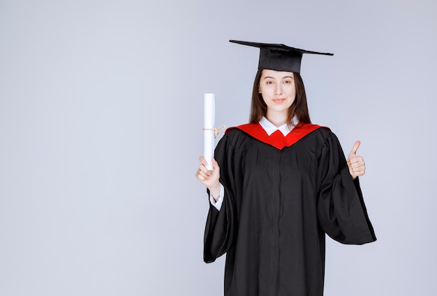 Female student with college diploma posing to camera. High quality photo