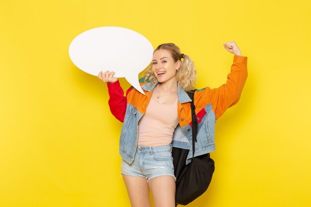 female student young in modern clothes holding white sign with flexing on yellow