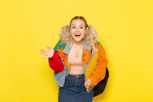 female student young in modern clothes holding yellow files with laugh on yellow