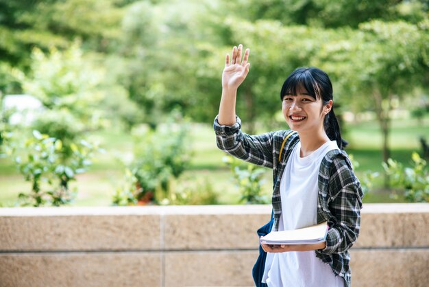 여학생들은 계단에 서서 책을 들고 있습니다.