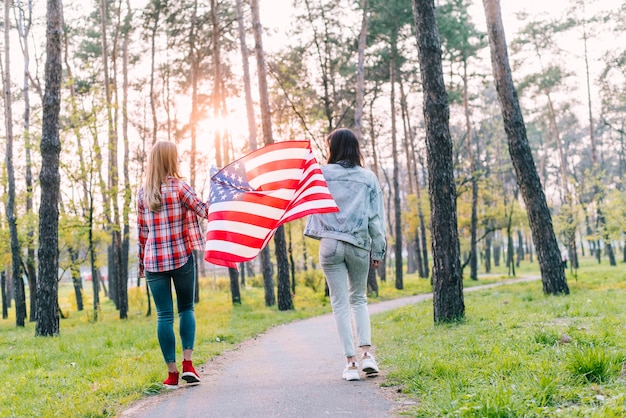 Female students with flag of USA in park