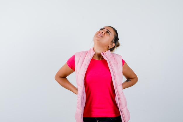 Female suffering from backache in t-shirt, vest and looking tired 