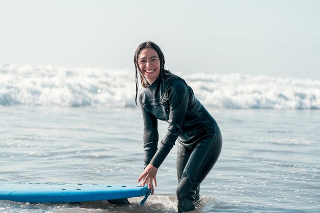 서핑 보드 행복으로 물에 서 있는 여성 서퍼 초상화
