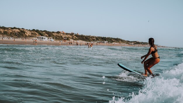 Female surfing on small waves