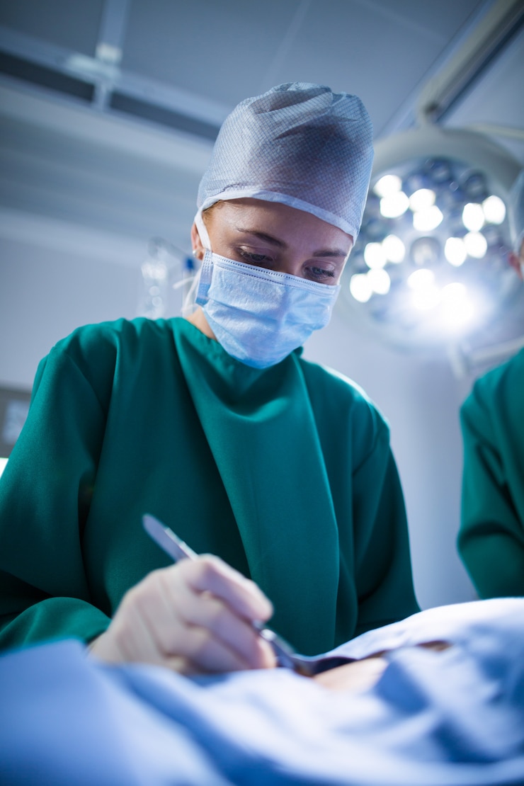 Free Photo female surgeon performing operation in operation theater