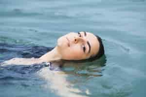Foto gratuita nuotatore femminile che fa aerobica di acqua nel lago