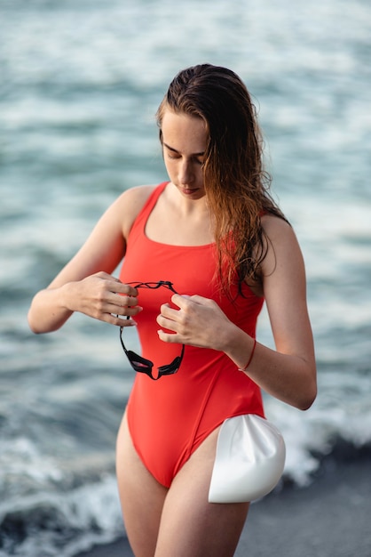 Female swimmer holding swimming goggles