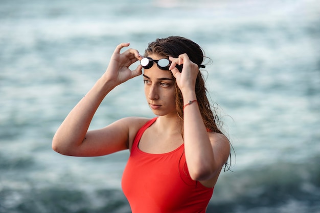 Free photo female swimmer putting on swimming goggles