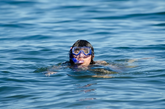 다이빙 마스크와 함께 물에서 수영하는 여성