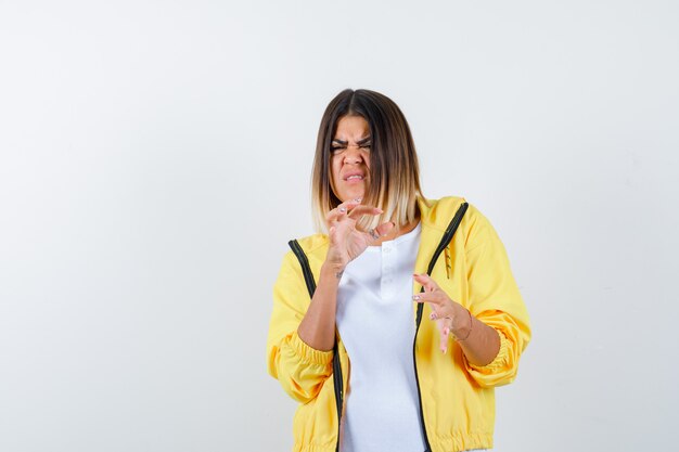 Female in t-shirt, jacket showing small size sign and looking dspleased , front view.