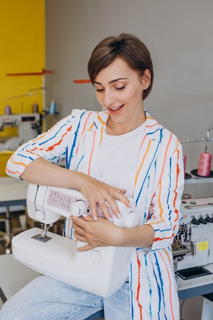 Free photo female tailor holding sewing machine