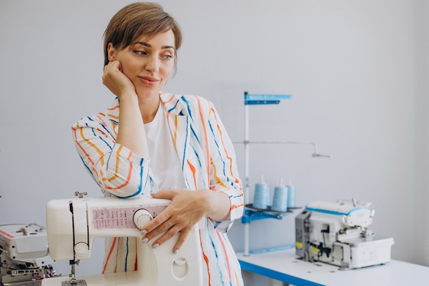 Female tailor holding sewing machine