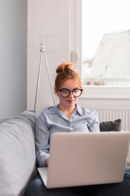 Female teacher on couch holding an online class