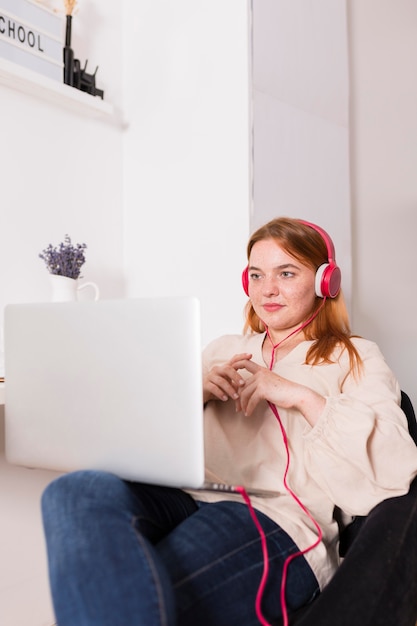 Female teacher at home listening to students during online class