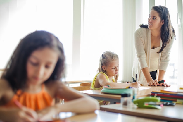 Free photo female teacher leaning upon table looking away