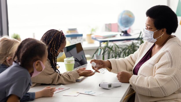 Female teacher teaching kids about disinfecting