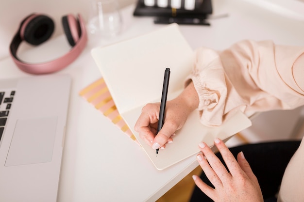 Female teacher writing something on agenda during online class