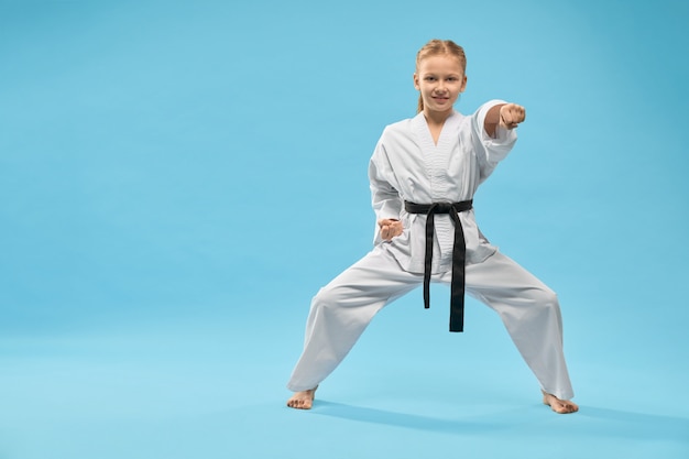 Female teenager standing in stance and punching in studio