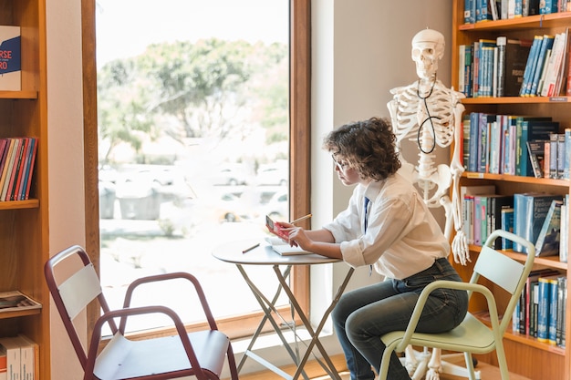 Foto gratuita adolescente femminile che utilizza calcolatore nella biblioteca