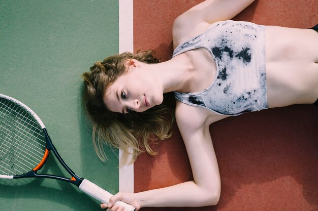 Female tennis player lying on ground