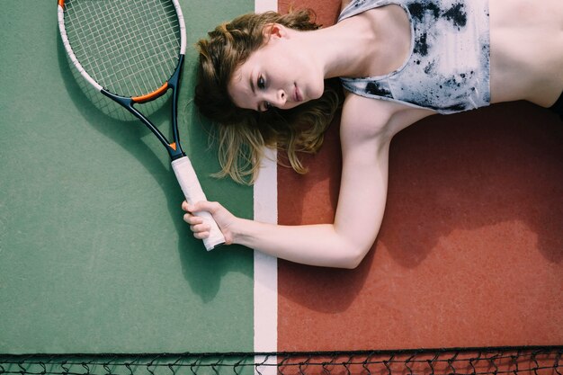 Female tennis player lying on ground