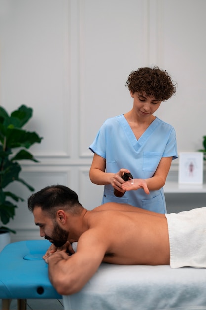 Foto gratuita terapista femminile nel centro di riabilitazione che restituisce massaggio