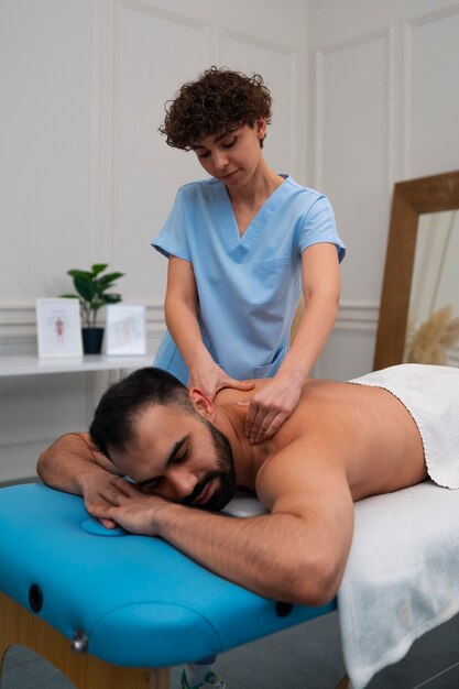 Female therapist in the rehabilitation center giving back massage