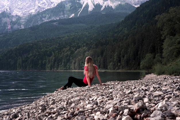 Туристка, наблюдающая за видом на покрытые зеленью холмы и горы возле деревни в Австрии