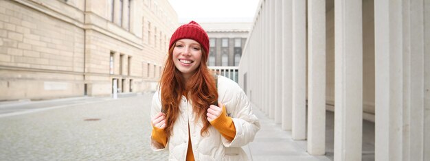 Free photo female tourist in red hat with backpack sightseeing explores historical landmarks on her trip around
