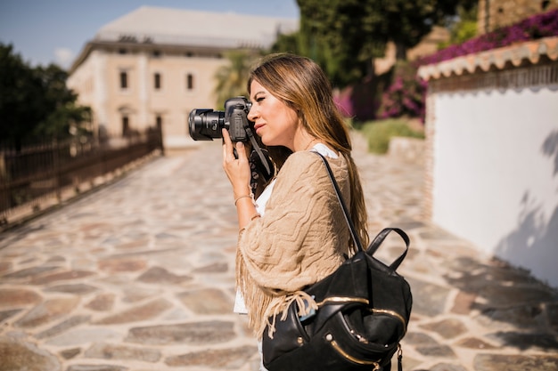 Женский турист фотографирует на камеру