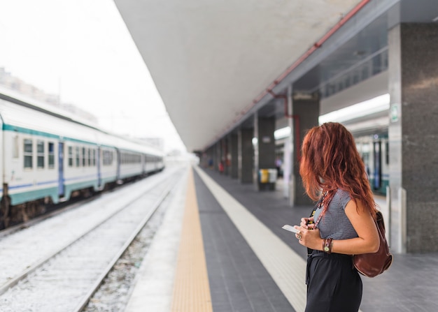 Foto gratuita turista femminile che aspetta treno