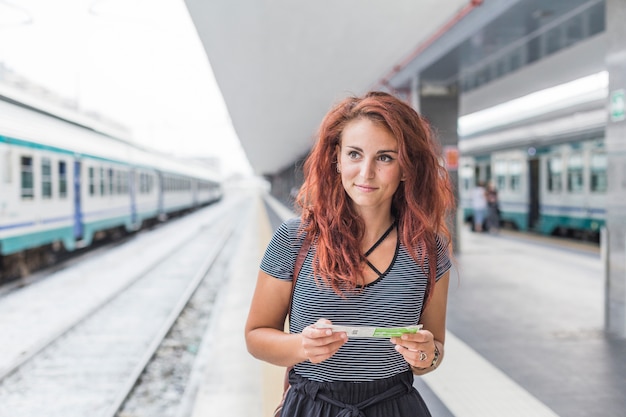 Женский турист ждет поезд